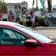 People wearing masks drive past protestors rallying against a mask mandate in Las Vegas, Nevada on August 22, 2020.